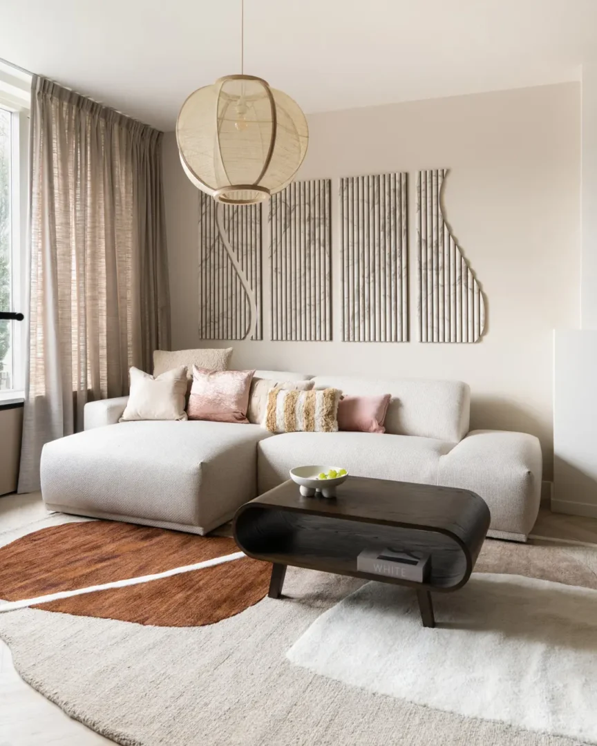 Groot vloerkleed genaamd Carpet Ogani 240x340 cm | By-Boo met organisch patroon in zachte aardetinten in een moderne, sfeervolle woonkamer.