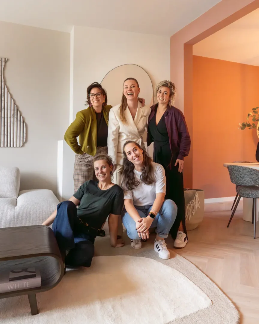 Het team van The Homestyle Club samen in een stijlvolle, huiselijke setting met moderne meubels en warme accenten.