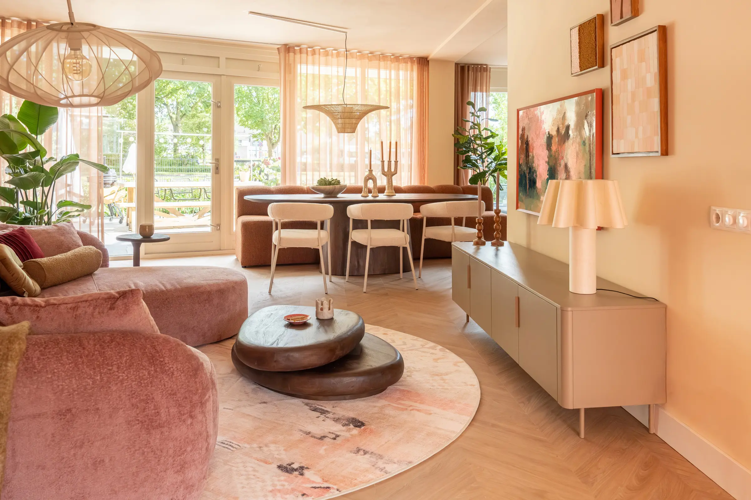 Warme woonkamer met terracotta bank, licht organisch vloerkleed en donkerbruine organische houten salontafel.