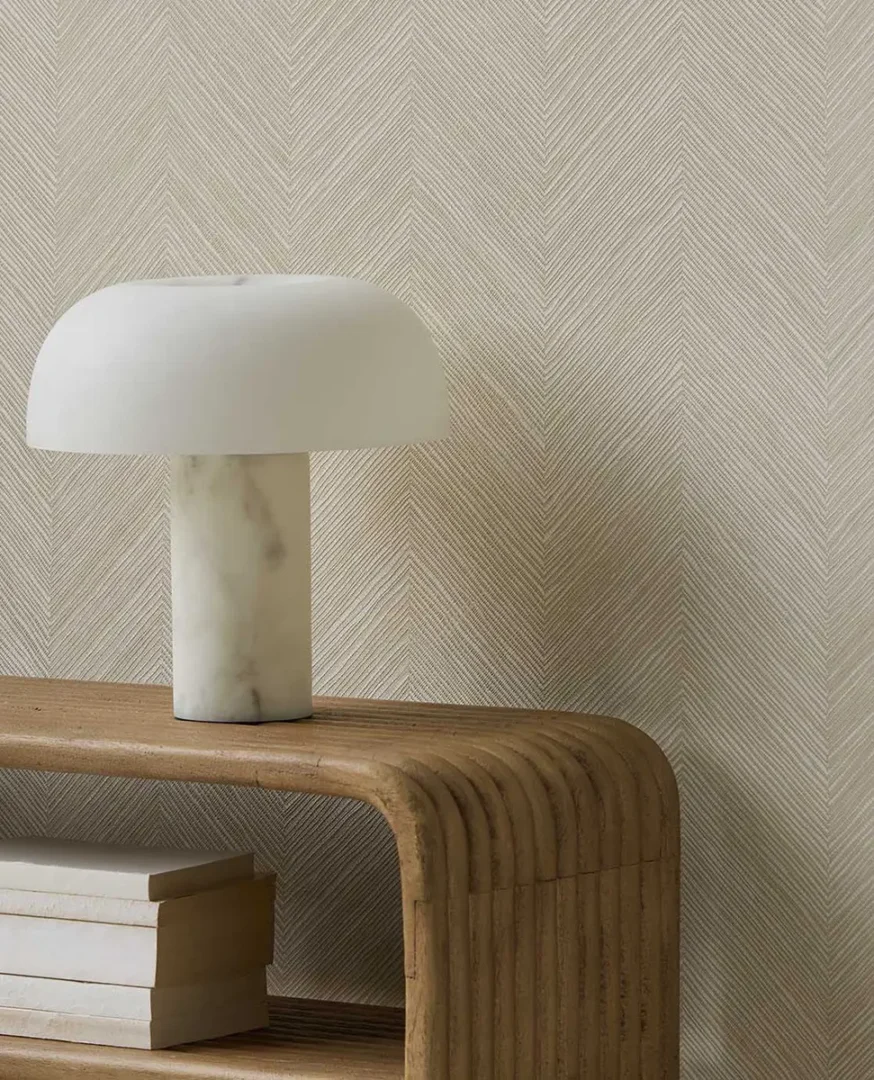 Marmeren tafellamp op een licht houten tafeltje met boeken eronder in een rustige, moderne setting.