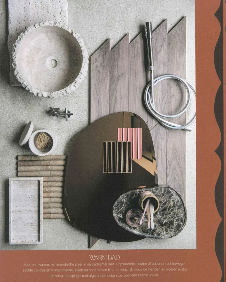 Flatlay met stenen waskom, houten panelen, metalen details, marmeren kraanplaat en een spiegel met afgeronde hoeken op een grijze ondergrond.